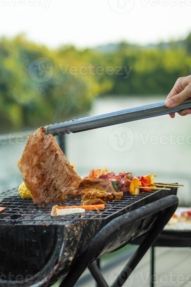 utsökt grillat kött med rök, bbq med grönsaker utomhus. grill, fest, livsstil och picknick koncept foto