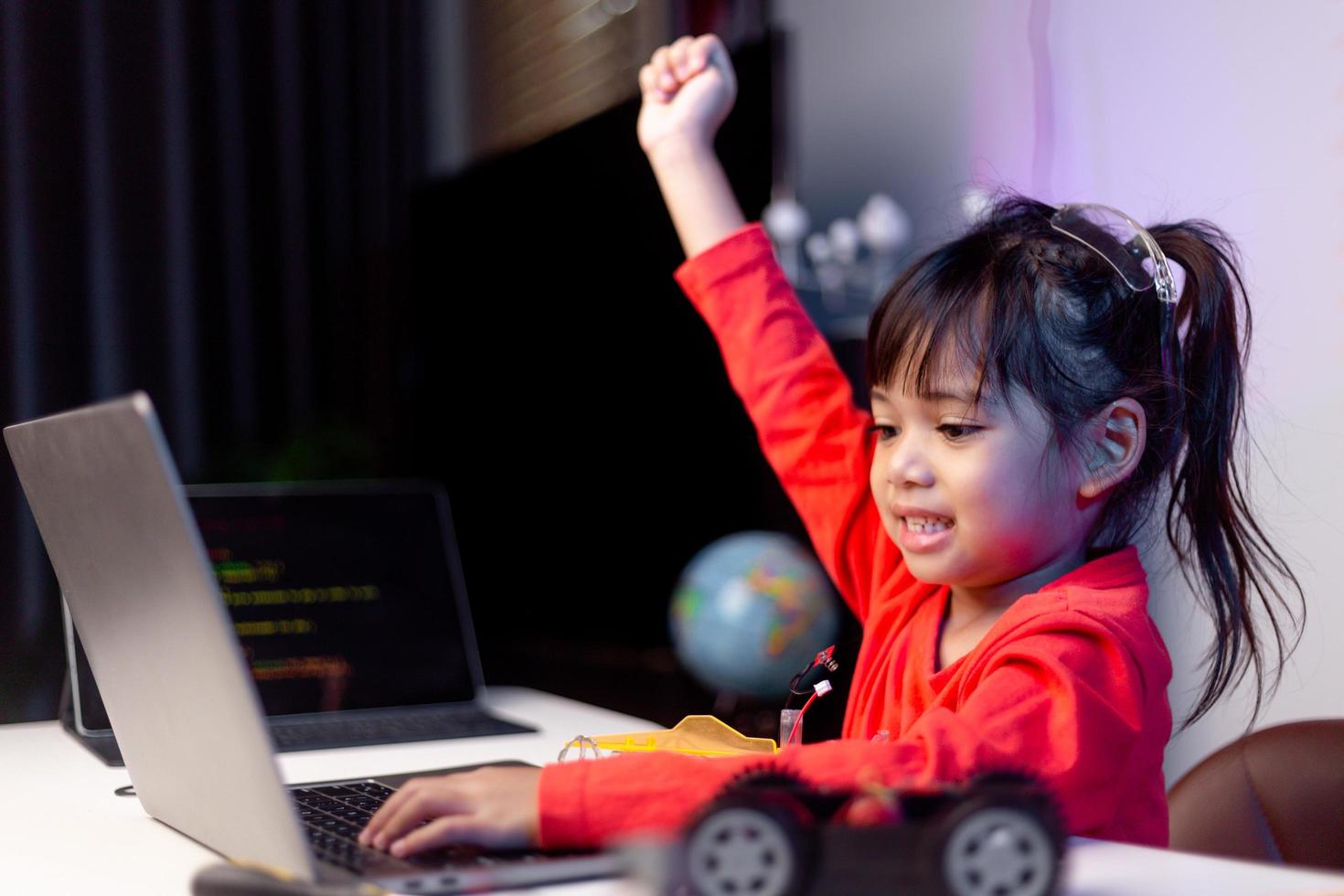 Asien-studenter lär sig hemma i kodning av robotbilar och kablar för elektronikkort i stam, steam, matematik ingenjör vetenskapsteknik datorkod i robotik för barn-koncept. foto