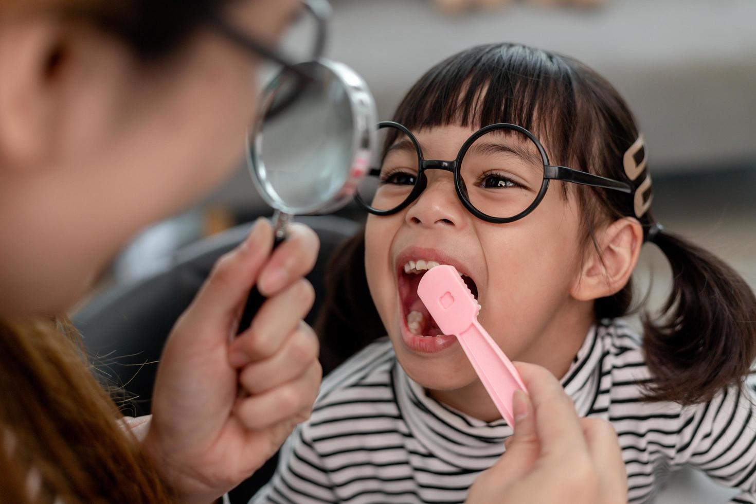 söta asiatiska barn som leker med läkare tandläkare leksaksset, barn visar hur man rengör och tar hand om tänderna. tandvård och medicin, foto