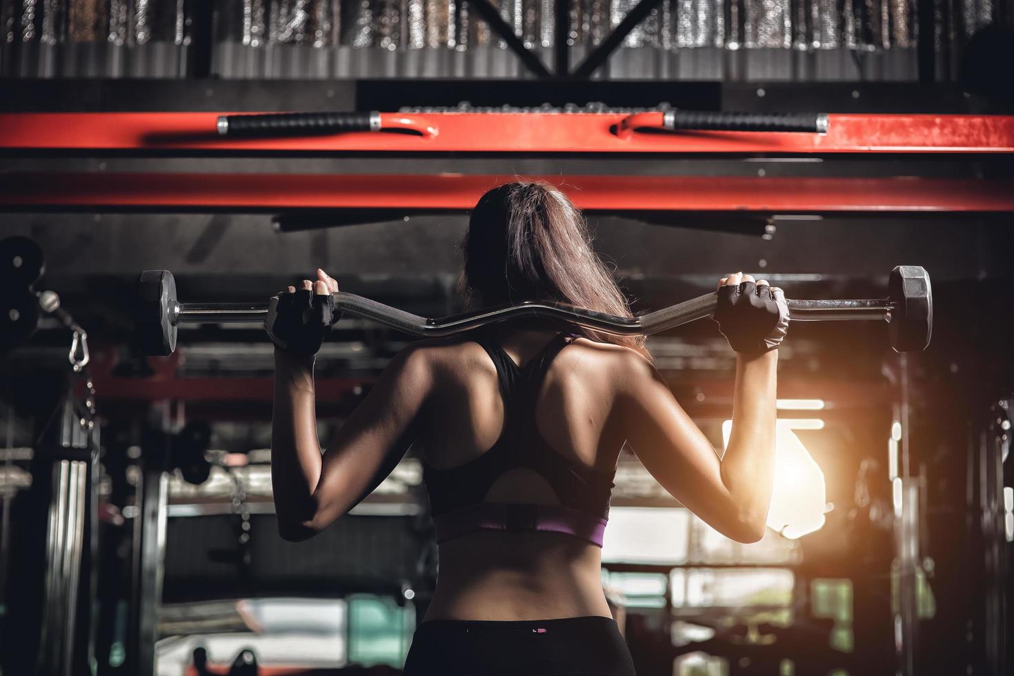 ung fitness kvinna utföra träning med träningsmaskin i gymmet foto