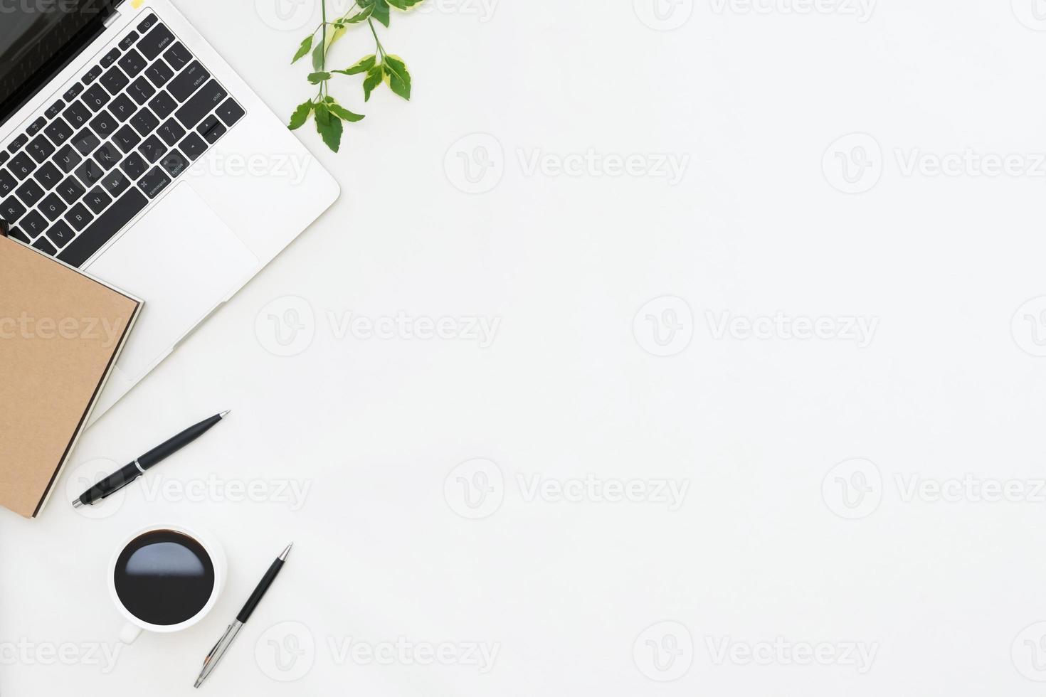 platt lekmannafoto av skrivbord med bärbar dator, anteckningsbok, penna, kaffe med kopieringsutrymmebakgrund foto