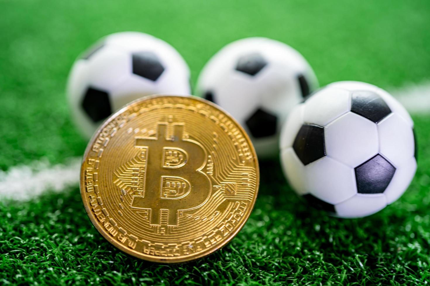 guld bitcoin med fotboll eller fotboll, kryptovaluta som används i sportspel online. foto