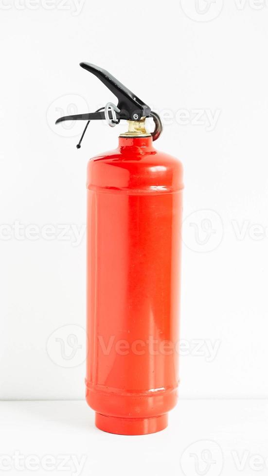 röd brandsläckare på en vit vägg bakgrund foto