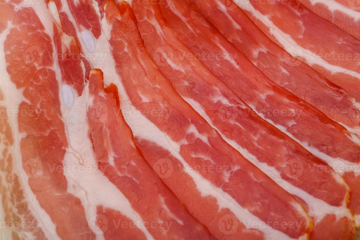 skivat bacon på en bräda foto