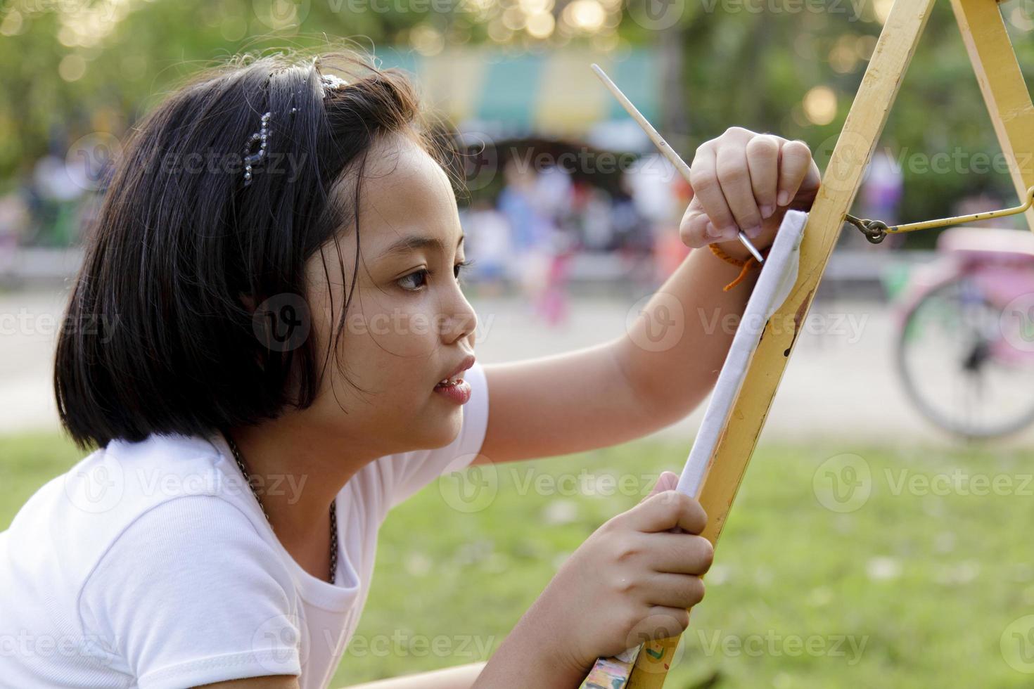 asiatisk liten flicka målning i parken foto