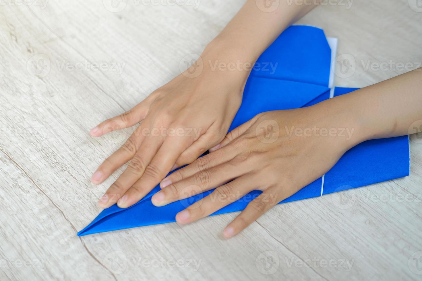 kvinnas hand vikning origami papper foto