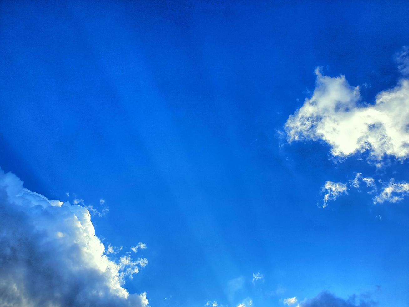 blå himmel med vitt moln och solstråle. för användning som bakgrund, bakgrund, tapeter, banner, mall. foto
