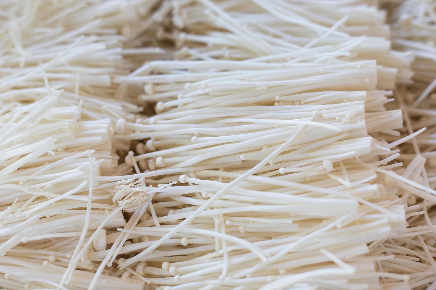 gyllene nål svamp har vit färg som den serverades i suki shabu och grillrestaurang. den har hög fiber och näringsämnen grönsaker. foto