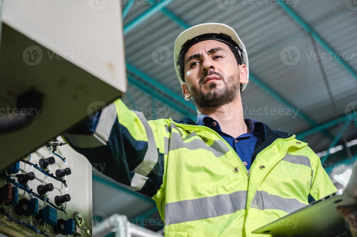 professionell tekniker ingenjör som arbetar med att kontrollera elkraft och säkerhetsservicesystem, elektriker som arbetar med underhåll och kontroll av industriell utrustning i termer av fabriksteknik foto