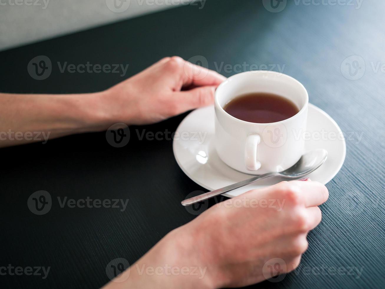 morgon kopp te i händerna på en ung kvinna foto