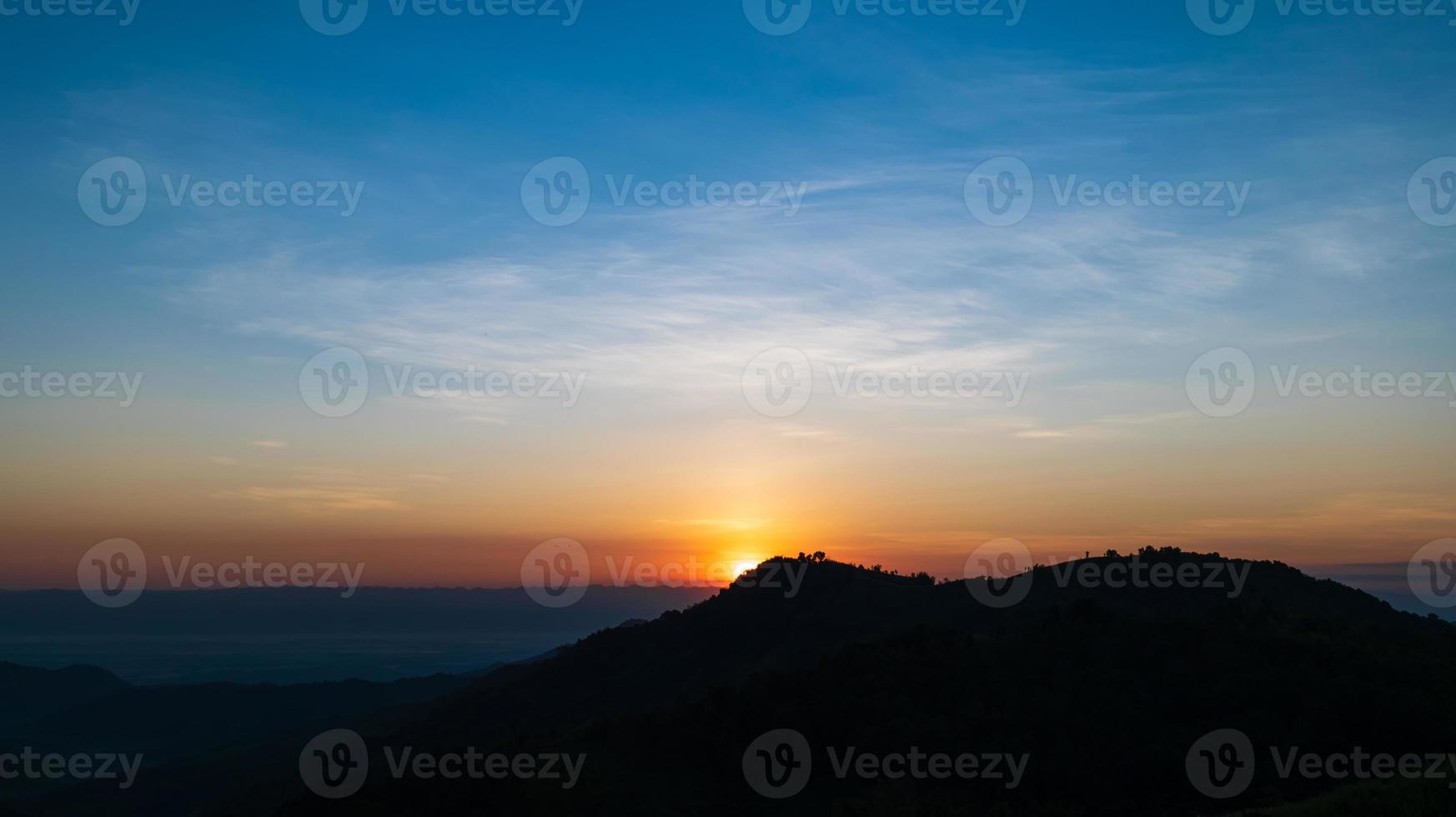 siluett av berg under soluppgången med himmel och moln. vackert naturlandskap på sommaren foto