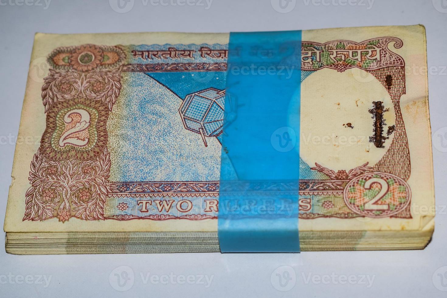 gamla två rupier sedlar kombinerade på bordet, indiska pengar på det roterande bordet. gamla indiska valutasedlar på ett roterande bord, indisk valuta på bordet foto