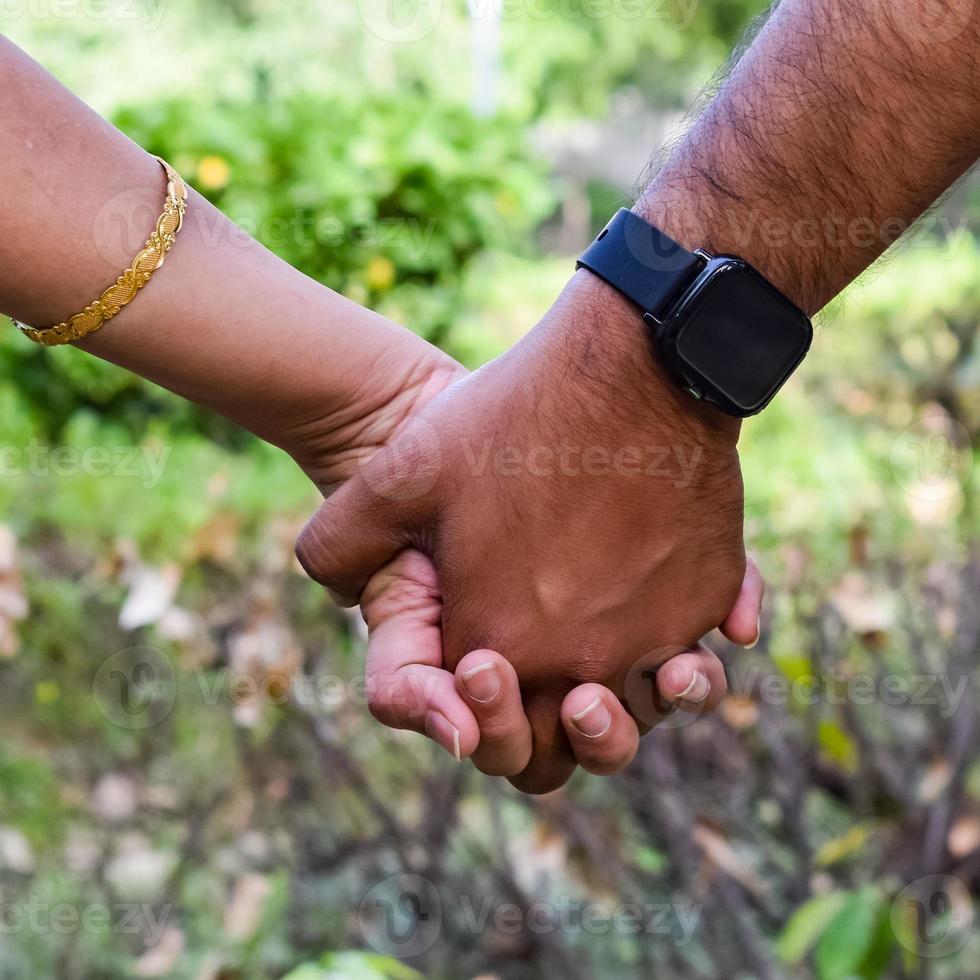 indiska par poserar för moderskap baby shoot. paret poserar i en gräsmatta med grönt gräs och kvinnan sviker sin babybula i lodhi garden i new delhi, Indien foto