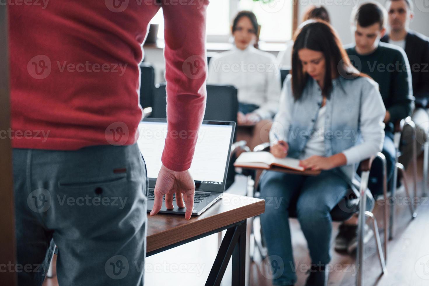 högtalare använder bärbar dator. grupp människor på affärskonferens i moderna klassrum på dagtid foto