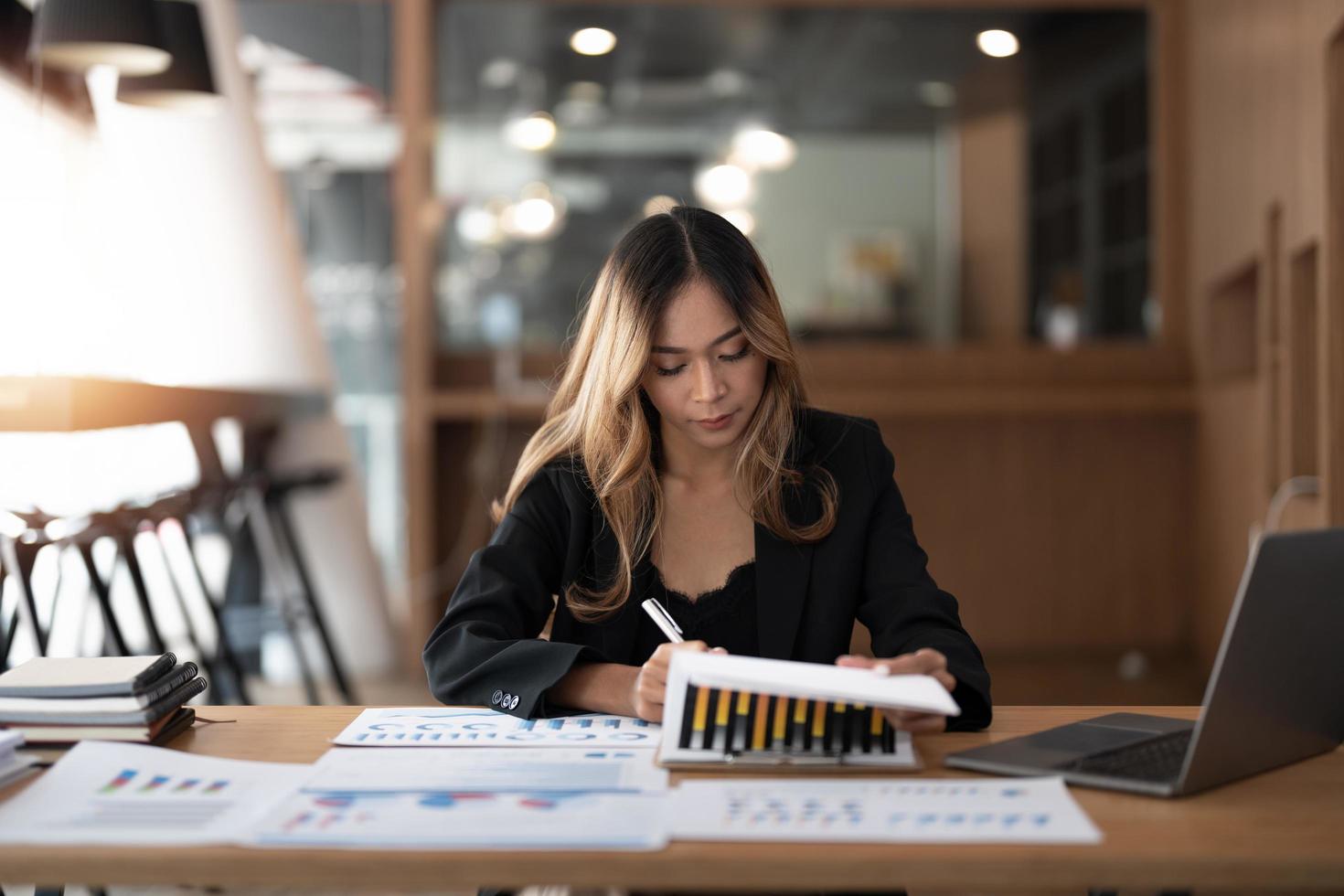 porträtt revisor asiatisk kvinna som arbetar och analyserar finansiella rapporter projektredovisning med diagramgraf och kalkylator i modern kontorsekonomi och affärsidé. foto