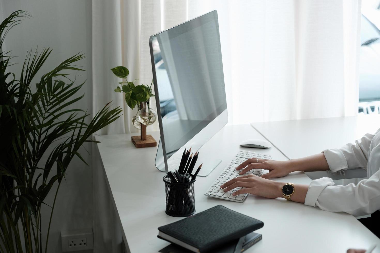 närbild av kvinna händer att skriva på datorns tangentbord inomhus. affärsman som arbetar på kontoret eller student surfar information foto