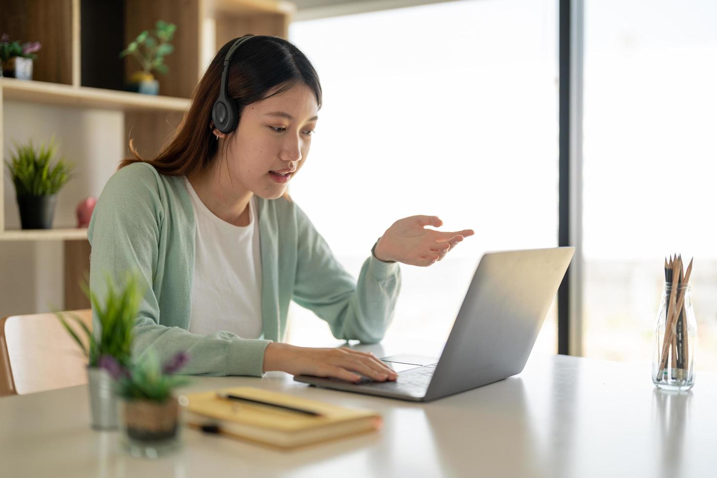 onlineinlärning, porträtt av glad asiatisk kvinnlig frilansare eller leende kvinnlig student som använder en bärbar dator för ett videosamtal med en lärare, distansutbildningskoncept foto