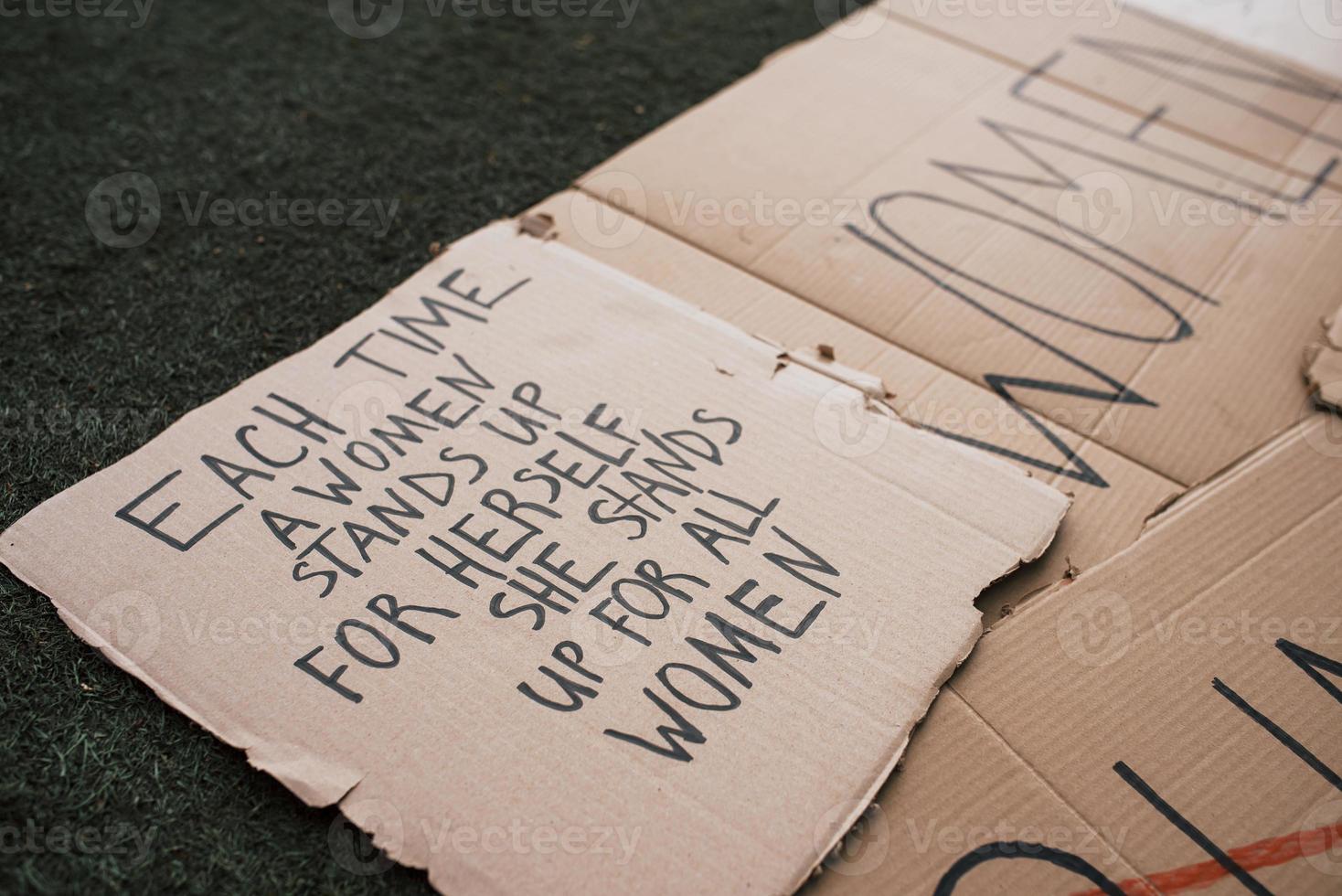 fokuserade på citatet. grupp av banderoller med olika feministiska citat liggande på marken foto