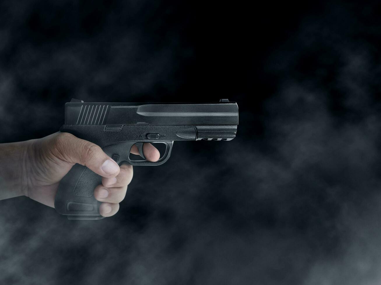 närbild av pistol i boss maffia hand på svart bakgrund foto