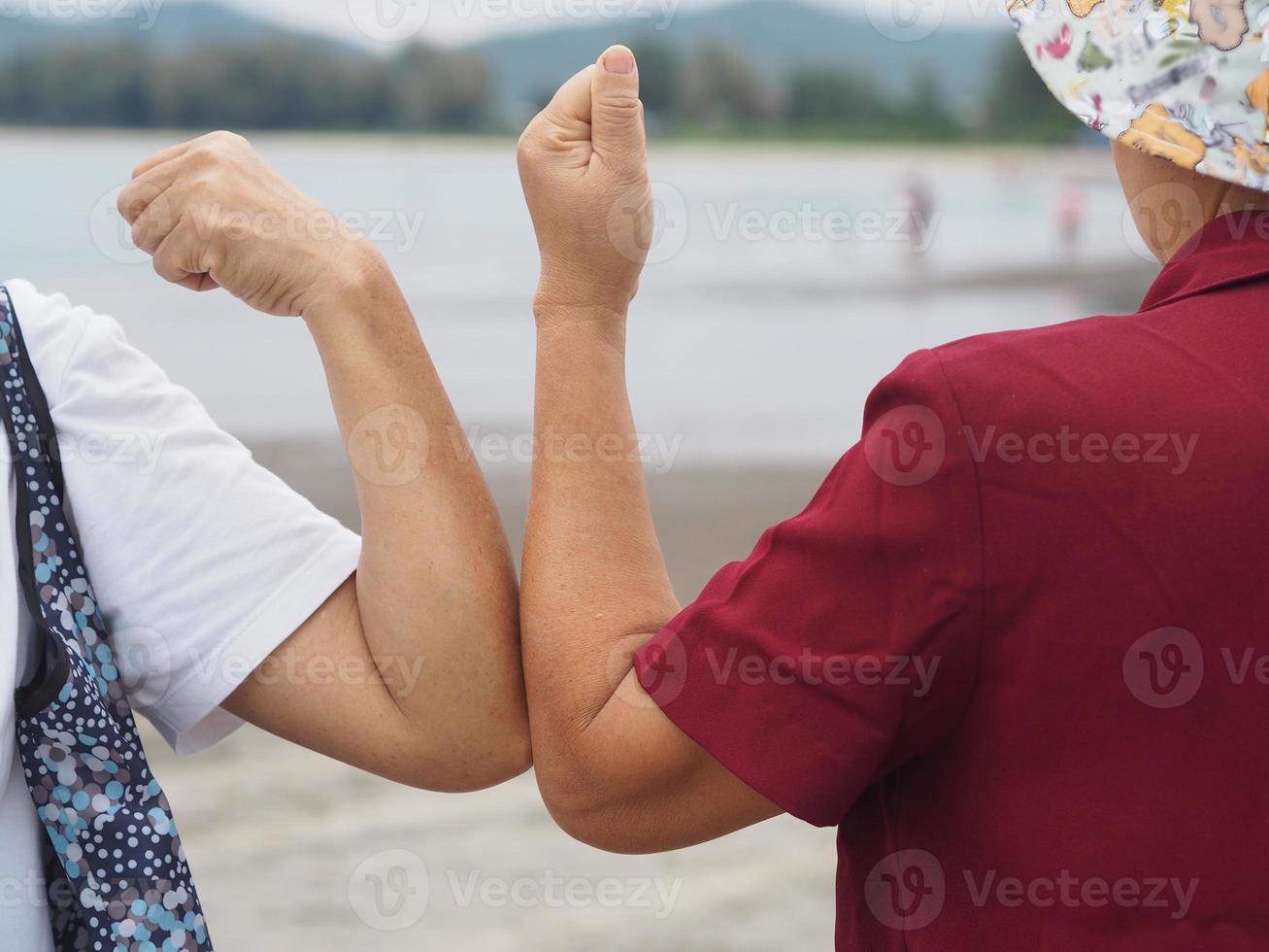 två kvinnor alternativa handslag armbågsbula hälsning i situationen av en epidemi covid 19, coronavirus ny normal social distansering foto