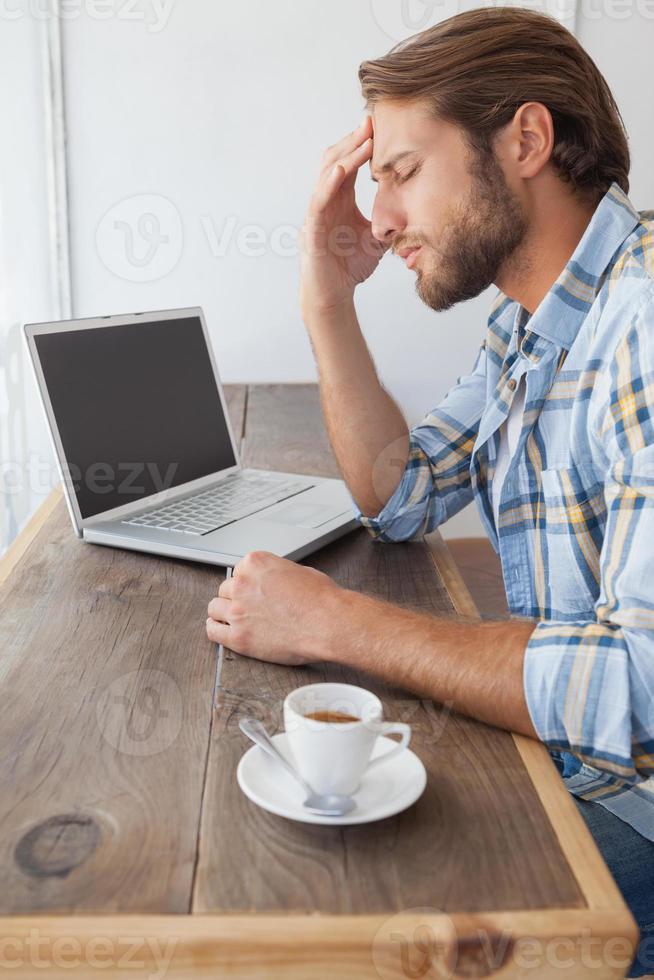 casual man använder bärbar dator med kaffe foto