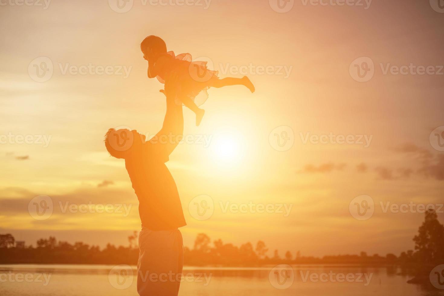 pappa tog barnet lära sig att gå i solnedgången. foto