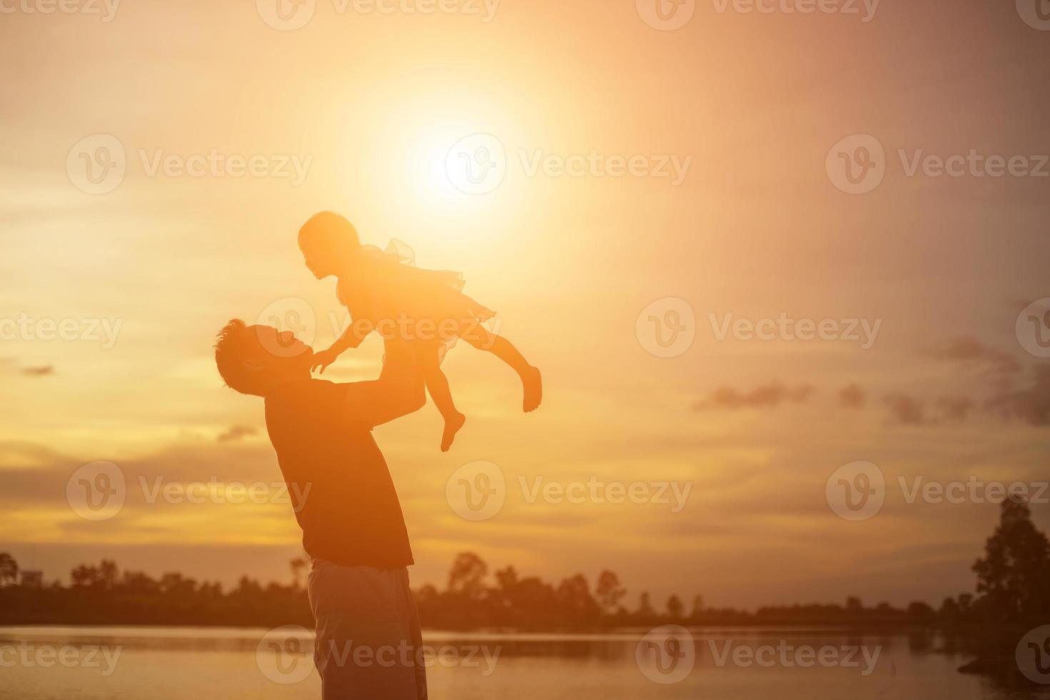 pappa tog barnet lära sig att gå i solnedgången. foto