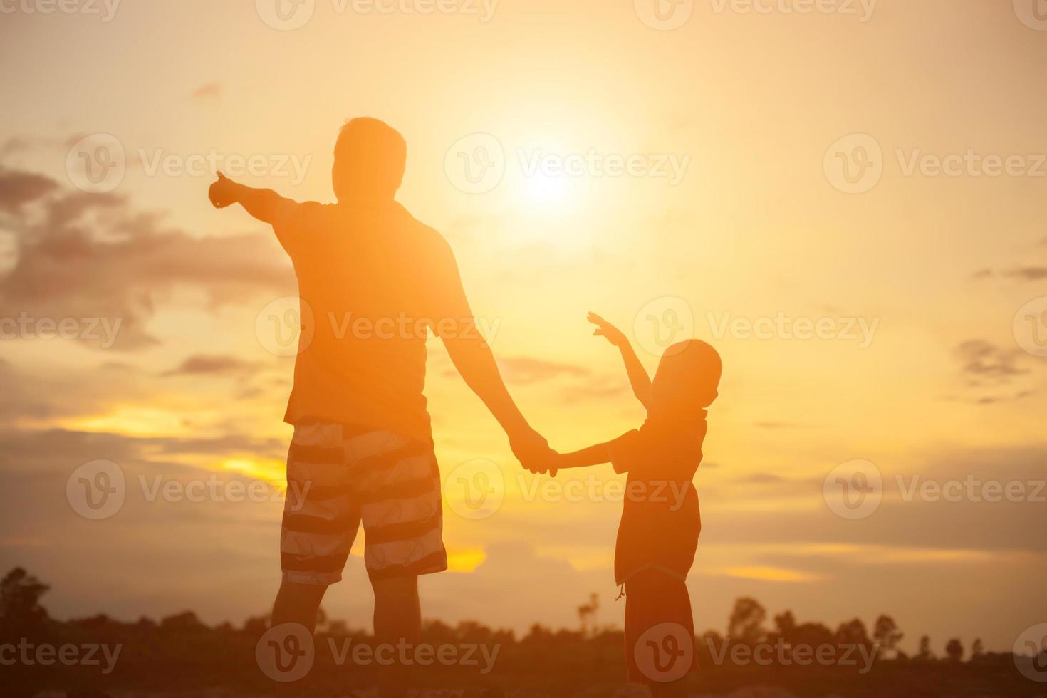 glad pappa kastar barnet i solnedgången foto