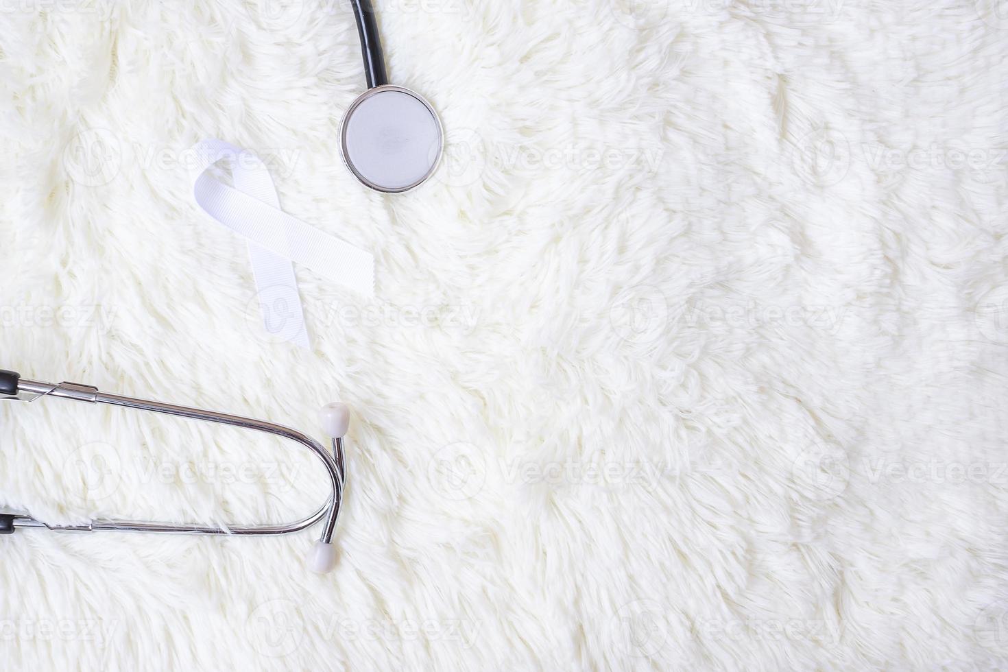 vitt band med stetoskop på vit bakgrund. november lungcancer medvetenhet månad koncept foto