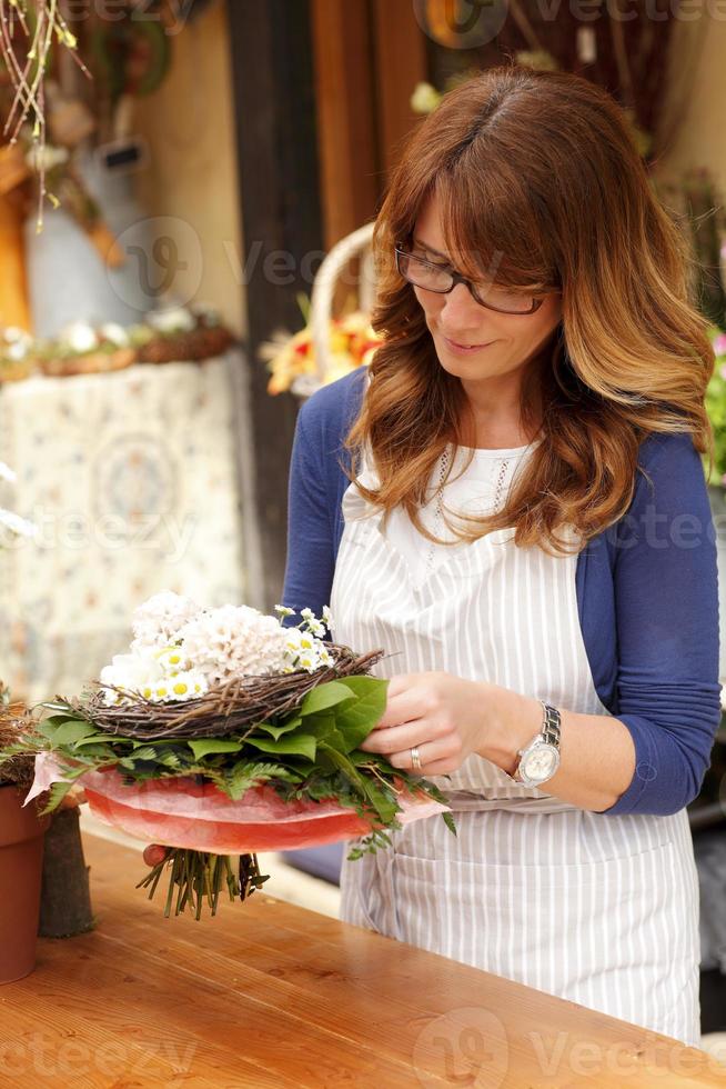 vacker kvinna som arbetar i blomsterbutik foto
