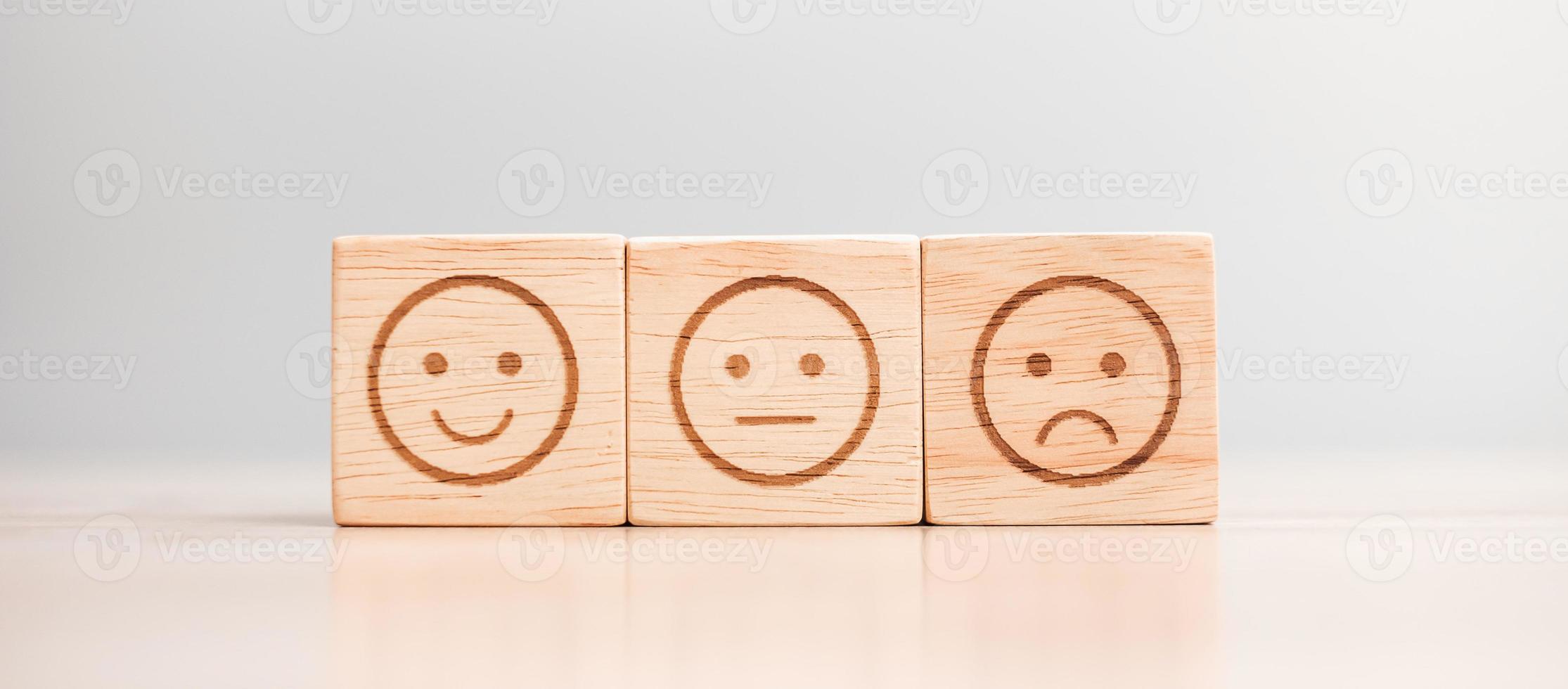 känslor ansikte symbol på trä block. servicebetyg, ranking, kundrecension, nöjdhet, utvärdering och återkopplingskoncept foto