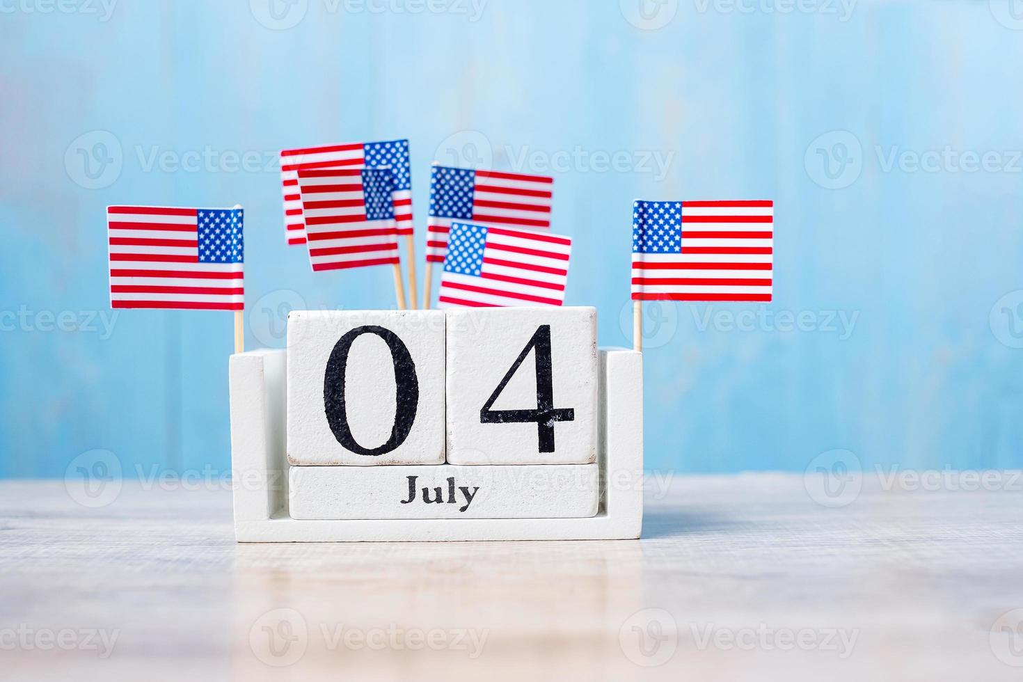 trä kalender 4 juli med miniatyr USA flagga på trä bakgrund. självständighetsdagen och nation semester koncept foto