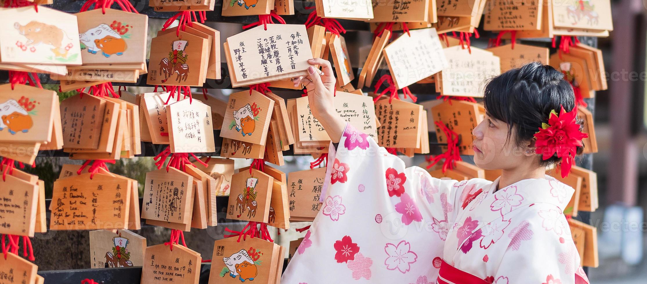 ung kvinna turist bär kimono i kiyomizu dera tempel, Kyoto, Japan. asiatisk tjej med frisyr i traditionella japanska kläder under höstens lövverk säsong foto