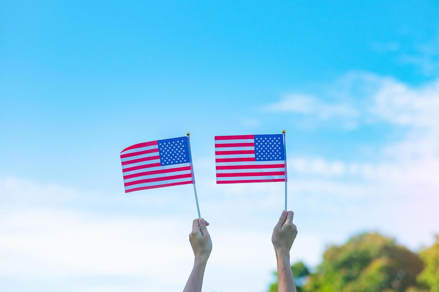 hand som håller USAs flagga på blå himmel bakgrund. USA semester för veteraner, minnesmärke, oberoende och labor day koncept foto
