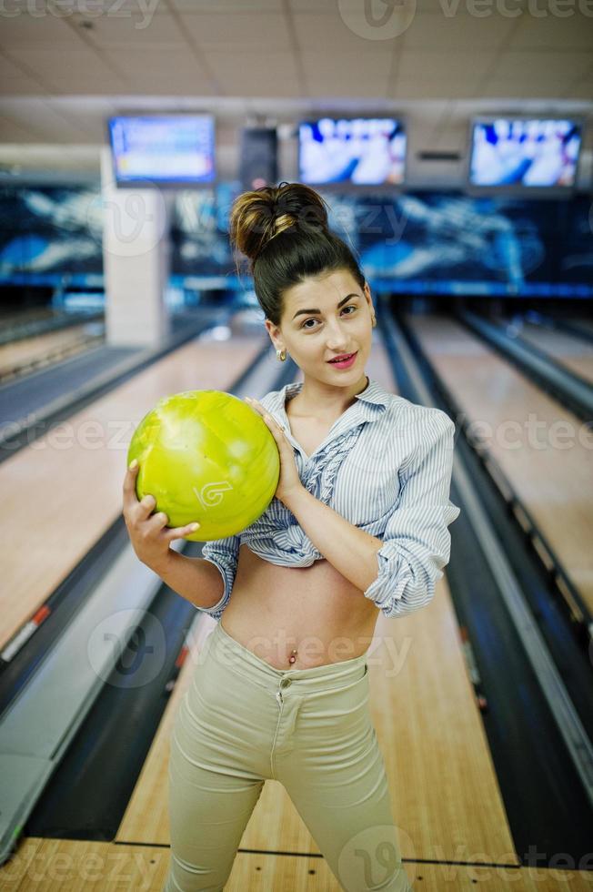 flicka med bowlingklot på gränden spelade på bowlingklubben. foto