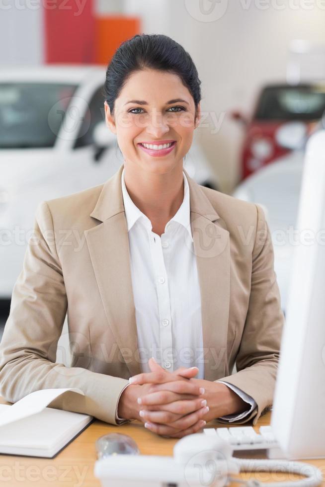 glad affärskvinna som arbetar vid hennes skrivbord foto