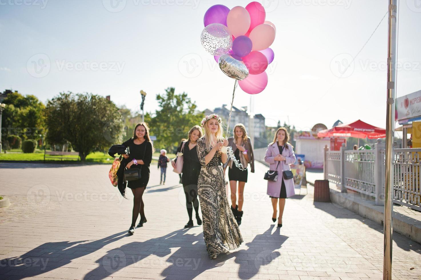 fem flickor bär på svart gå med ballonger på möhippo. foto
