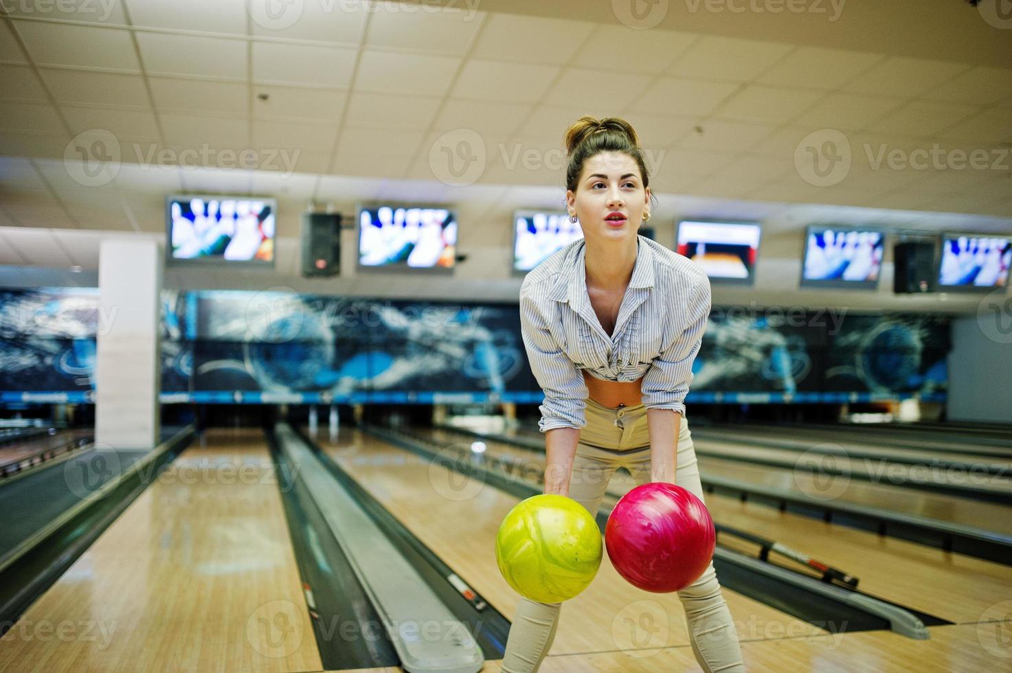 flicka med bowlingklot på gränden spelade på bowlingklubben. foto