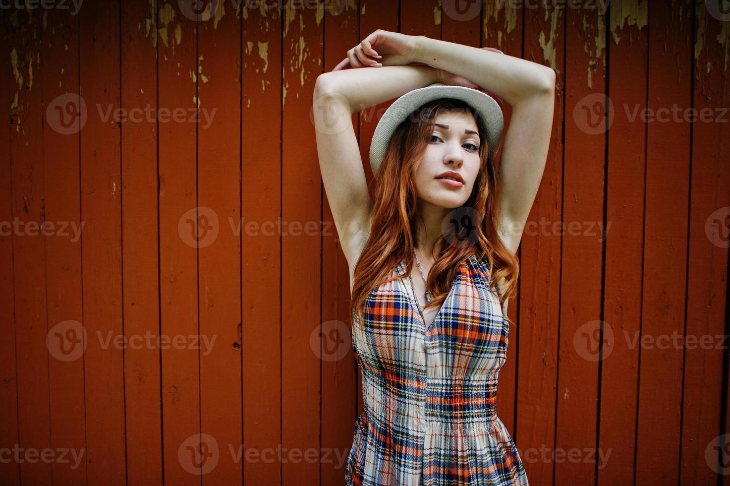 fantastiska långa ben med höga klackar flicka bär på hatt mot trä bakgrund. foto