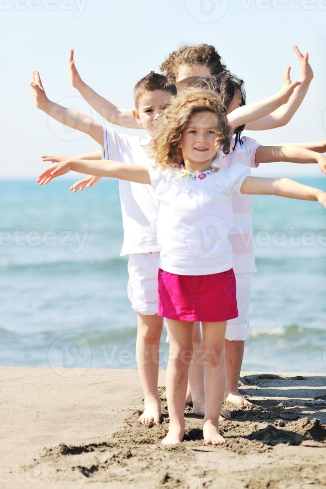 glad barn grupp som leker på stranden foto