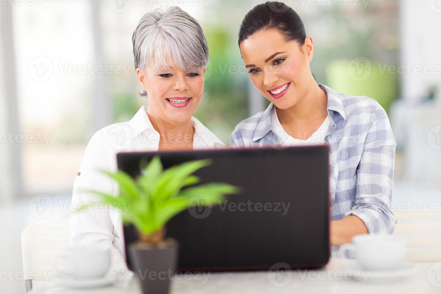 äldre mamma och dotter som använder bärbar dator foto
