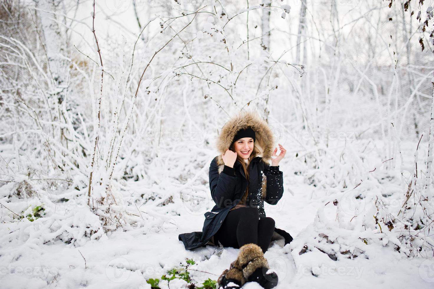 vacker brunett flicka i vinter varma kläder. modell på vinterjacka och svart mössa. foto