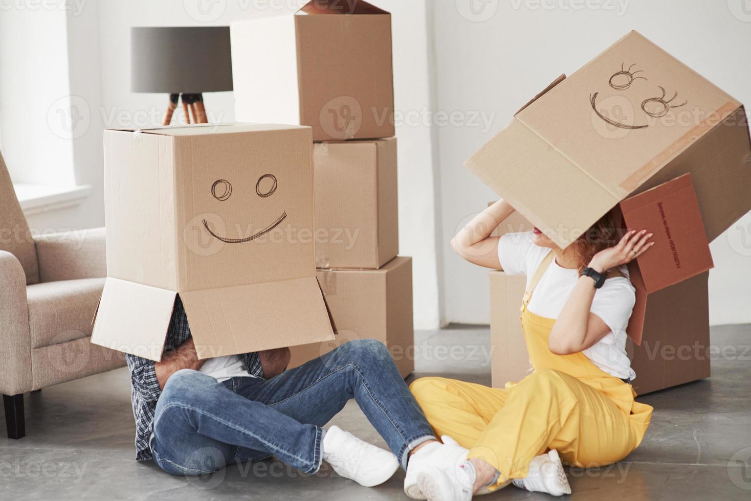 lådor på huvudena. lyckligt par tillsammans i sitt nya hus. föreställning om att flytta foto