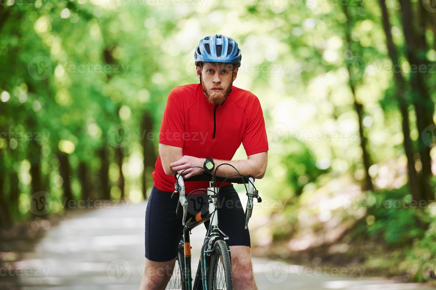 avkoppling mellan maraton. cyklist på en cykel är på asfaltvägen i skogen på en solig dag foto