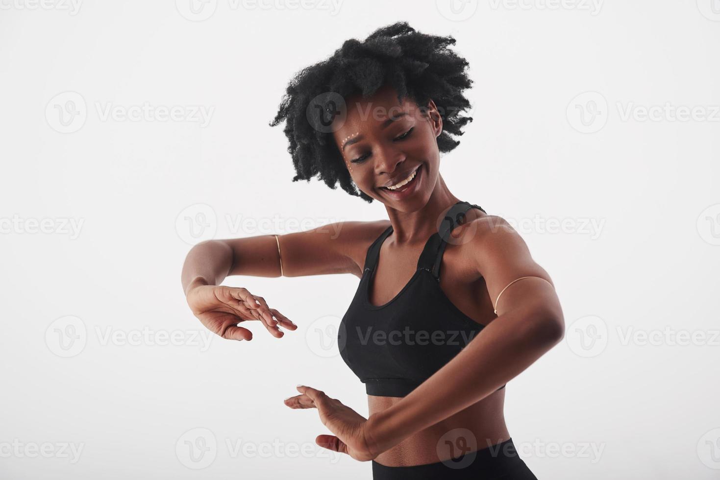 Känn rytmen. ung vacker afroamerikansk kvinna i studion mot vit bakgrund foto