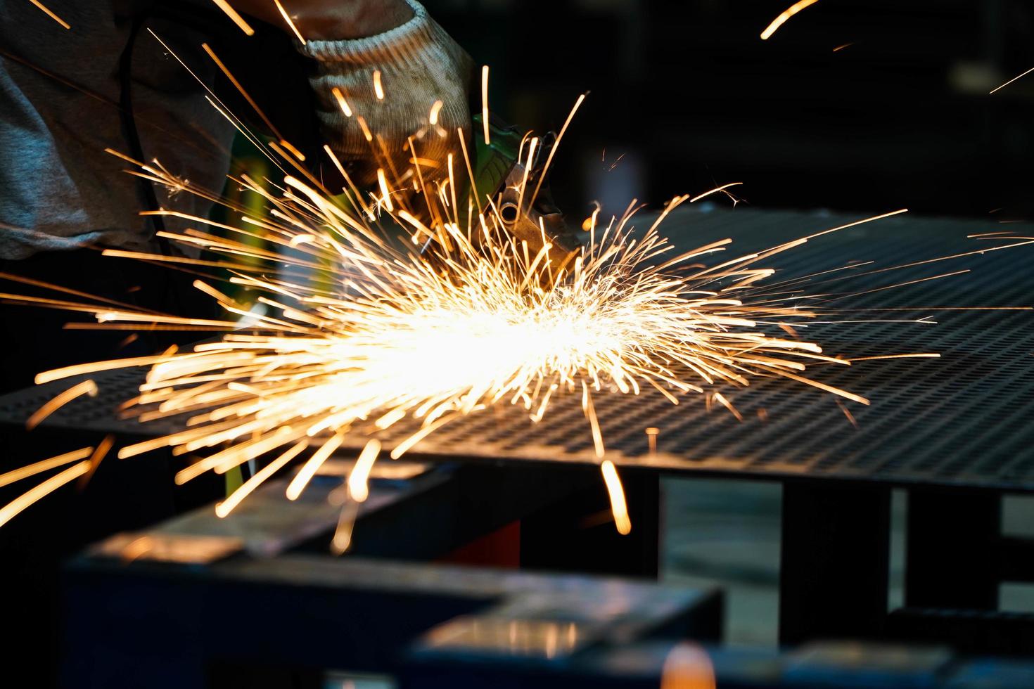 elektrisk järnslipmaskin i fabrik gnistor från slipskivor foto