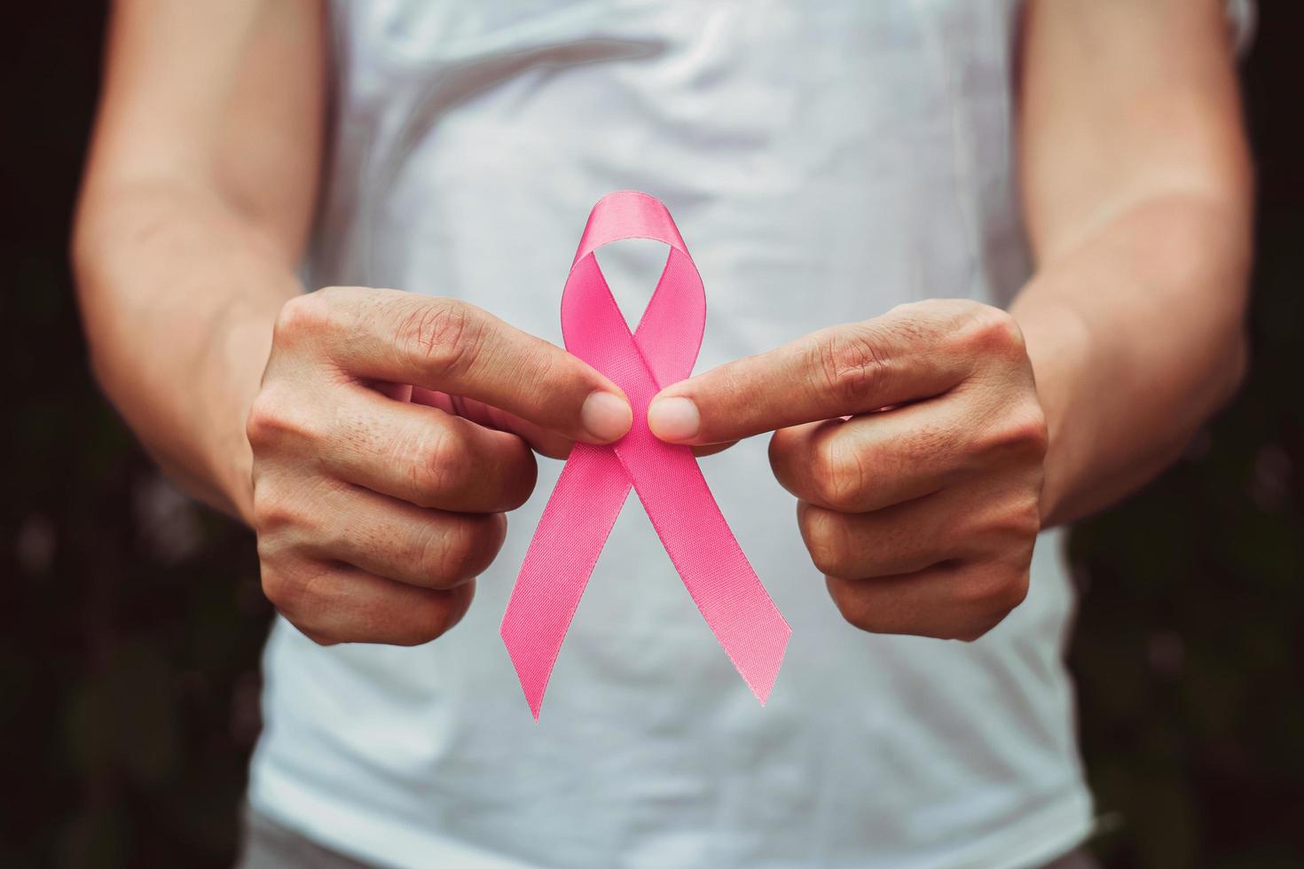 koncept sjukvård och medicin. hand som håller rosa band. Informationskampanj om bröstcancer. tecken på hopp foto