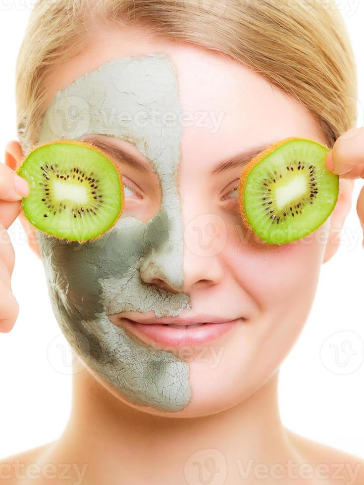 kvinna i lera ansiktsmask som täcker ögon med kiwi foto