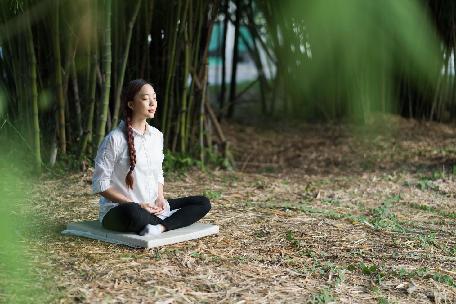 porträtt ung flicka gör meditation och yoga i bambuskog foto