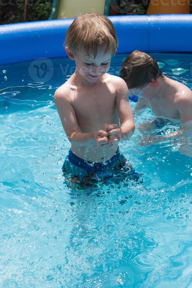leende ung pojke i poolen foto